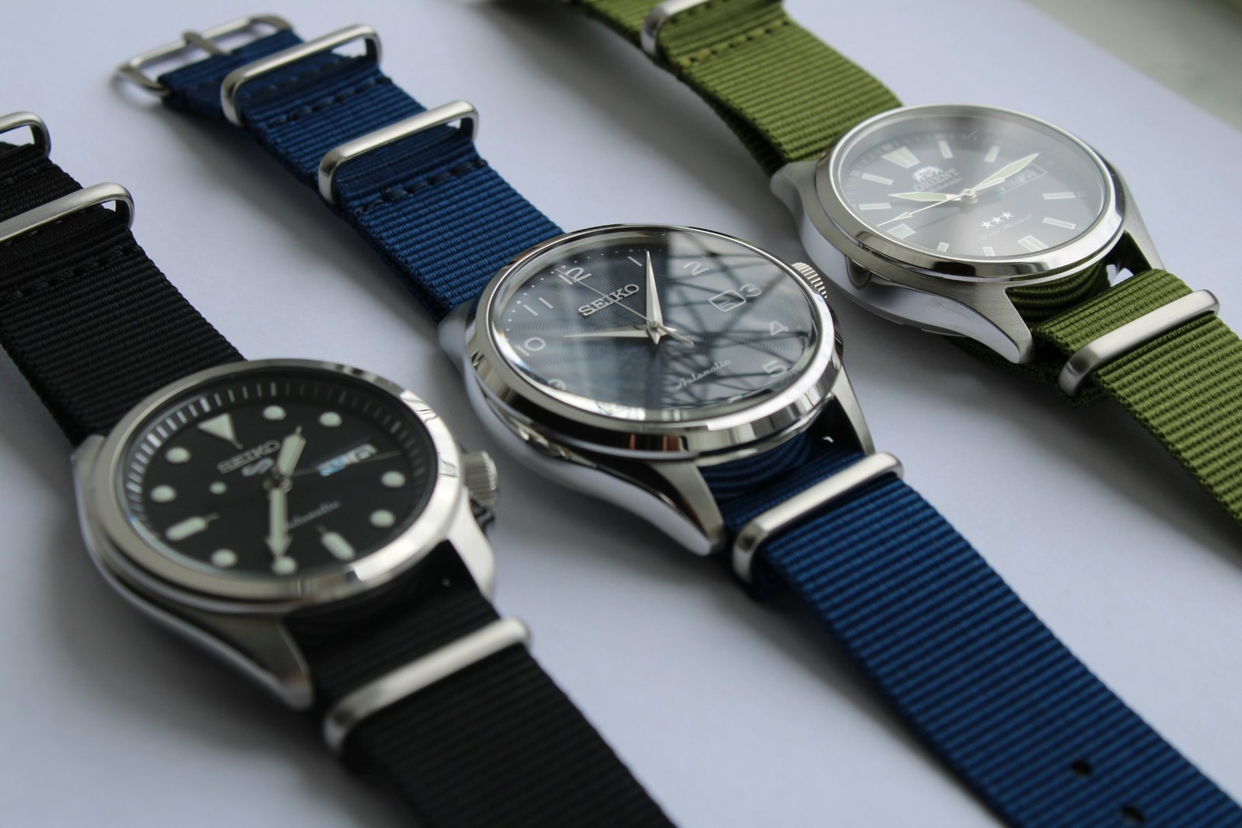 Três relógios automáticos Seiko e Orient com pulseiras NATO